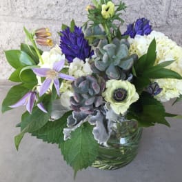 Mixed bouquet with purple and white flowers in a glass vase