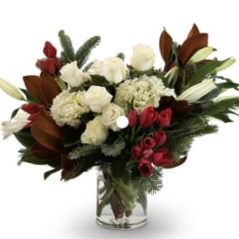 Bouquet of white roses, hydrangeas, and red tulips in a glass vase