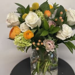 Mixed bouquet of white and orange flowers in a glass vase