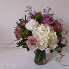 Mixed pink, white, and purple bouquet in a glass vase