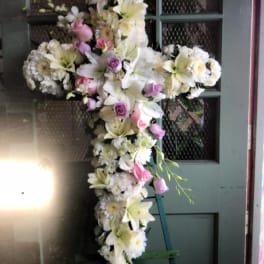 Cross-shaped floral spray with white lilies, daisies, and pink roses