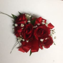 Red rose corsage with white baby's breath and ribbon