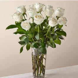 White roses arranged in a clear glass vase
