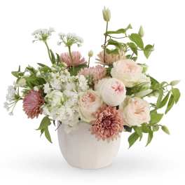 Pink and white floral arrangement in a white ceramic vase