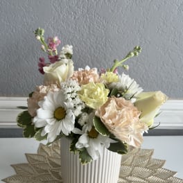 Pastel flower arrangement in a ribbed white vase