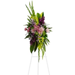 Tall floral spray with pink and purple flowers on a white easel
