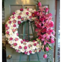 Large floral wreath with pink lilies and white daisies on a door