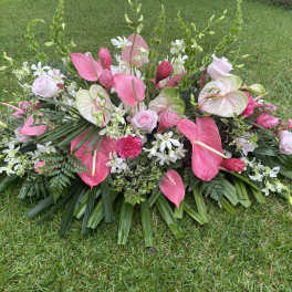 Large pink and white floral spray arranged on grass