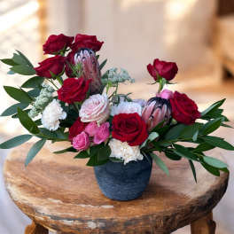 Arrangement of red and pink roses in a dark vase