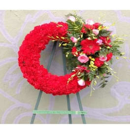 Red floral wreath on an easel with pink and white accents