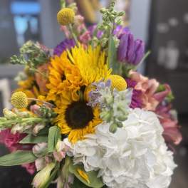 Mixed bouquet with sunflowers, white hydrangea, and purple blooms