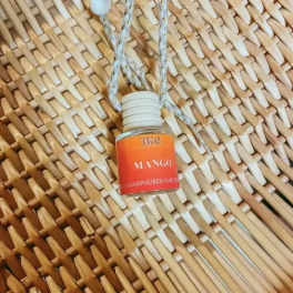 Small hanging bottle labeled mango on a woven background