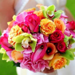 Bright mixed bouquet of roses and orchids in pink, orange, and green