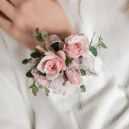 Small pink rose corsage with ribbon and greenery