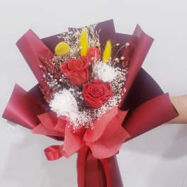 Bouquet of red roses with white filler flowers and red wrapping