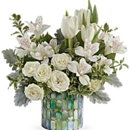White tulips and roses arranged in a mosaic vase