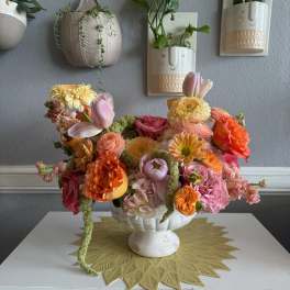 Colorful flower arrangement in a white pedestal bowl