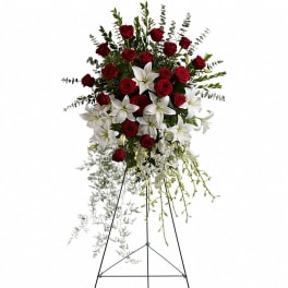 Tall standing spray of red roses and white lilies on a black metal easel