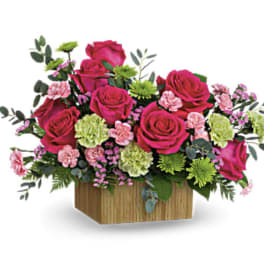 Pink roses and carnations in a wooden box