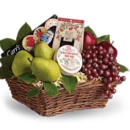 Fruit gift basket with pears, grapes, and packaged cheese in a wicker basket