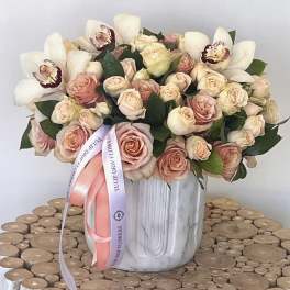 Bouquet of blush roses and white orchids in a white vase