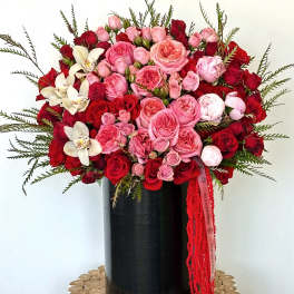 Large bouquet of pink and red roses in a black vase
