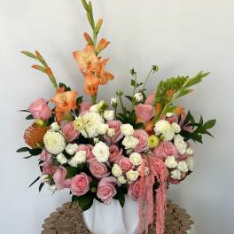 Pink and white floral arrangement in a white vase