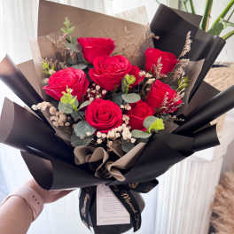 Bouquet of red roses wrapped in black paper