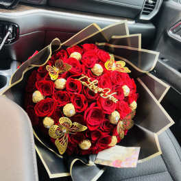 Red rose bouquet with gold-wrapped chocolates and butterfly decorations