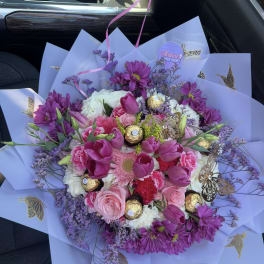 Bouquet of pink and purple flowers with gold-wrapped chocolates