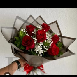 Bouquet of red roses with white baby's breath in dark wrap