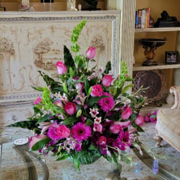 Pink floral arrangement with roses, lilies, and gerbera daisies in a low vase