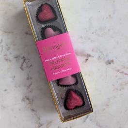 Box of heart-shaped chocolate truffles in pink and dark chocolate