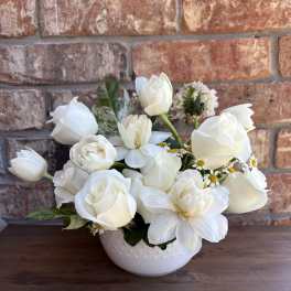 White roses and tulips arranged in a white bowl vase