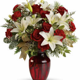 Red roses and white lilies in a red glass vase with gold accents