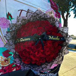 Large bouquet of red roses with a black ribbon and Spanish text