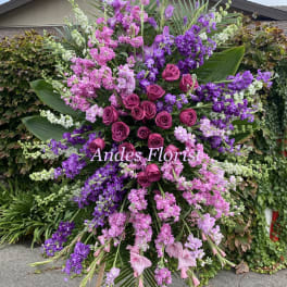 Large standing floral spray with pink and purple roses and blossoms