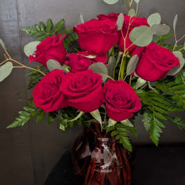 Bouquet of red roses in a burgundy glass vase
