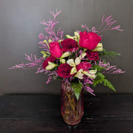 Pink roses and burgundy carnations in a glass vase