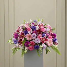 Large bouquet of pink, purple, and white flowers in a tall gray vase