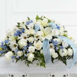 White and blue floral arrangement with a light blue ribbon