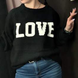 Person wearing a black sweater with the word LOVE in white letters