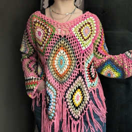 Person wearing a colorful crocheted poncho with fringe