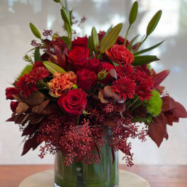 Red roses and chrysanthemums arranged in a glass vase