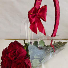 Bouquet of red roses wrapped in clear plastic with a red ribbon handle