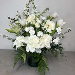 White roses and lilies arranged in a dark vase