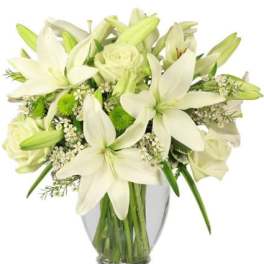 White lilies and roses arranged in a clear glass vase
