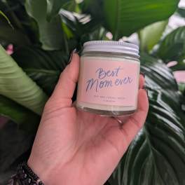 Hand holding a small candle jar labeled "Best Mom ever"
