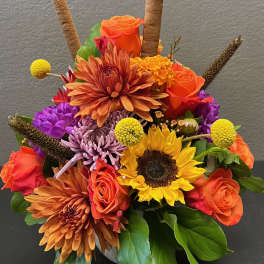 Bright mixed bouquet with sunflowers, orange roses, and purple mums