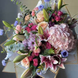 Mixed bouquet with pink roses, lilies, and hydrangea in paper wrap